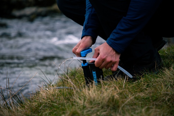 filtrování vody z potoka přes cestovní filtr na vodu Lifesaver Wayfarer